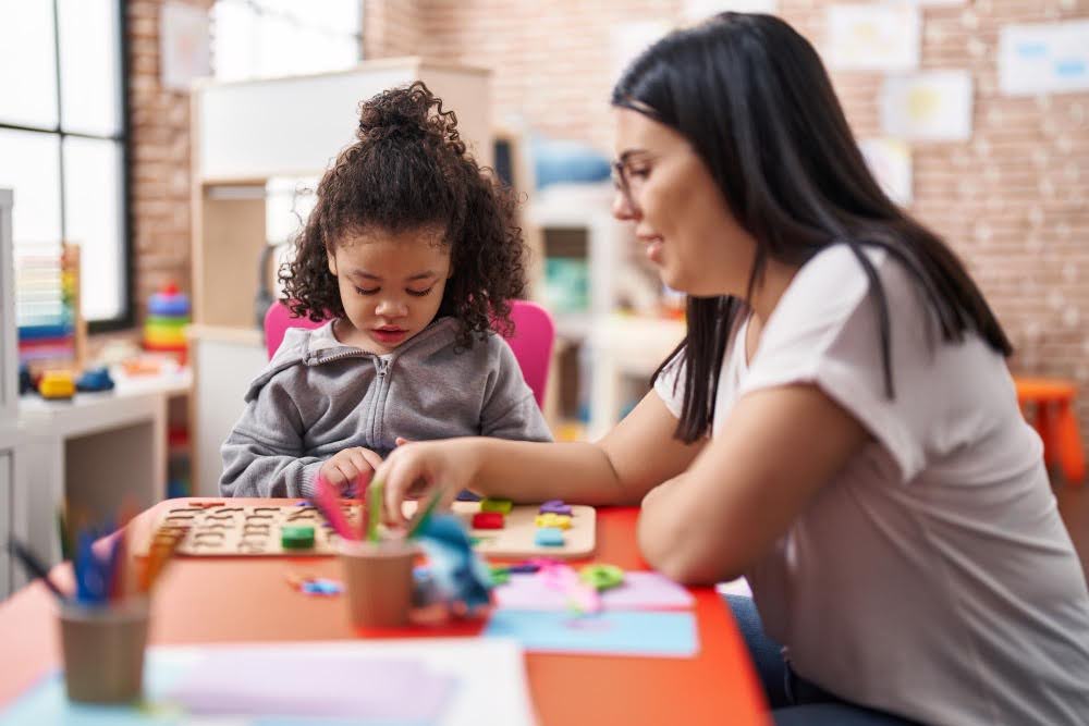 Criança e educadora em ambiente escolar